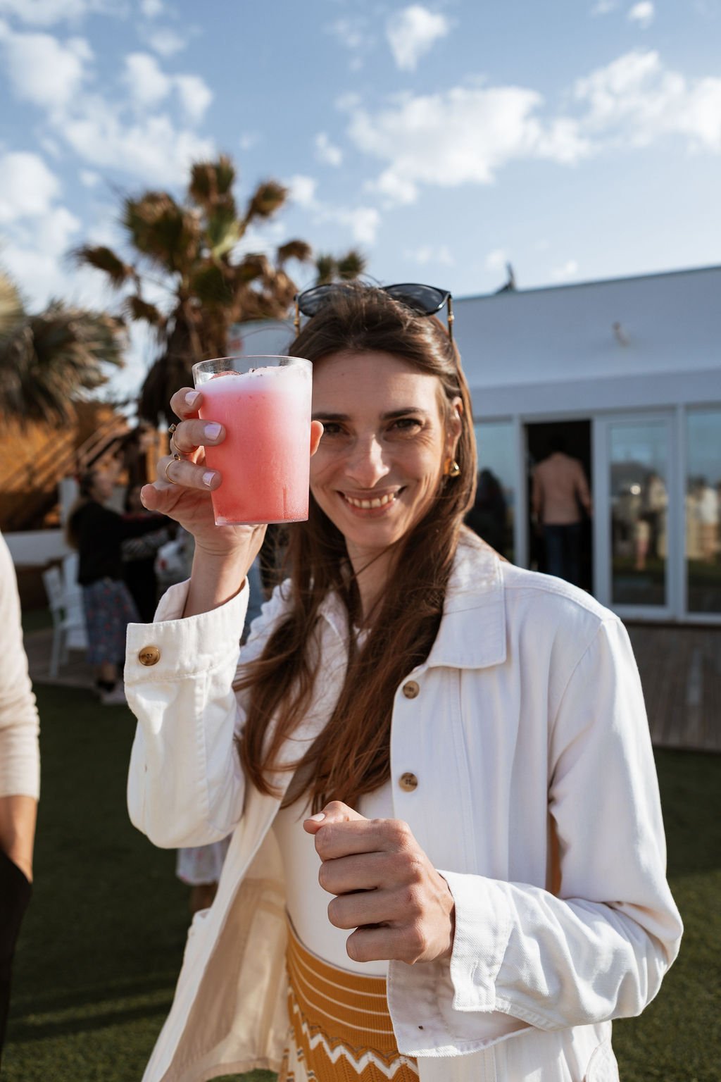 Invitada sonriendo con un cóctel de InFlow en la mano durante un evento privado en Fuerteventura